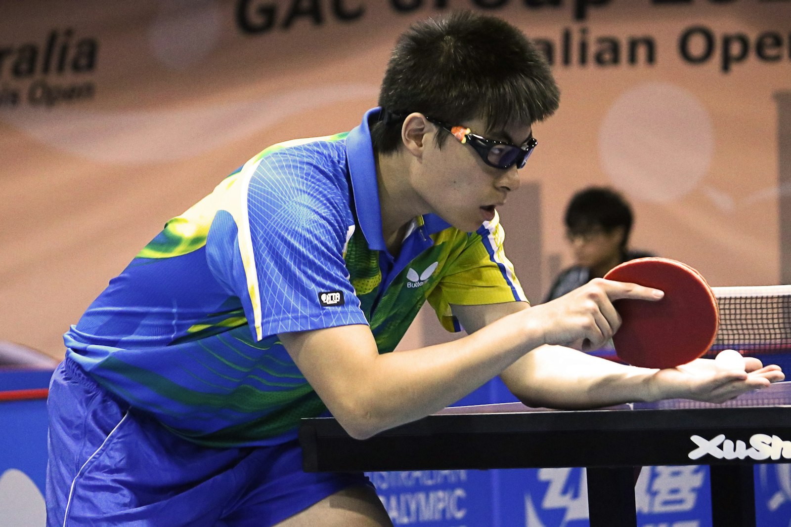 A player lining up a serve at the table